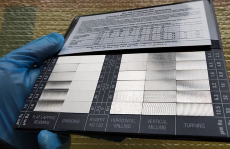 holding a surface roughness comparison specimen in hand